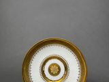 a white and gold plate with a circular design on it