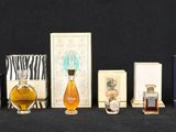 de nombreux flacons de parfum de toutes sortes alignés sur une surface noire