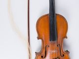 un violon et un archet posés sur une surface blanche