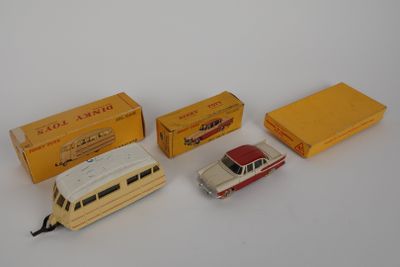 trois petites voitures et une boîte remplie de boîtes posées sur une surface blanche