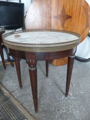 une petite table avec un plateau en marbre et des pieds en bois