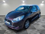 La voiture violette est garée sur un sol à damier dans le garage.