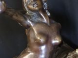 bronze statue of a woman and a lion on a black background