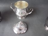 a silver cup with a lid and a silver cup with a lid and a silver cup with a lid and a silver cup with a lid