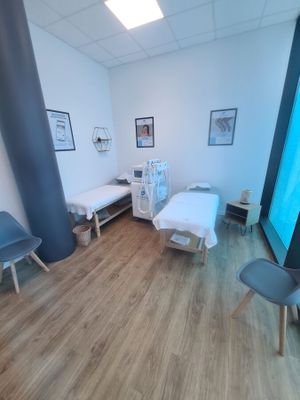 a picture of a hospital room with two beds and chairs