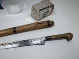 a knife, a hammer, and a glass of water on a table