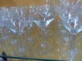 many empty wine glasses on a glass shelf