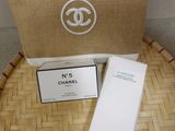 chanel makeup bag and lotion box on a bamboo tray