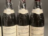 six bottles of wine are lined up in a row on a table