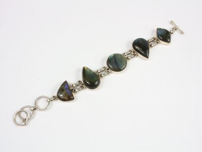 un gros plan d'un bracelet orné de pierres vertes et noires
