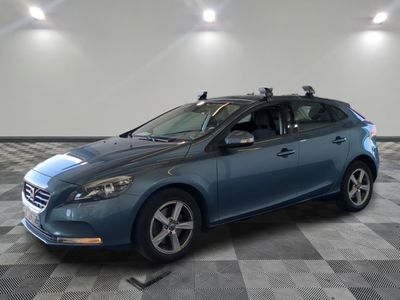 La voiture bleue est garée sur le sol à damier du garage.