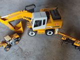 un engin de chantier miniature et un camion miniature posés par terre