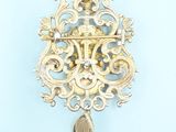 a gold brooch with a tear hanging from it ' s side