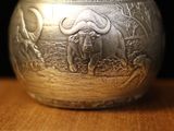 an image of a silver vase sitting on top of a wooden table