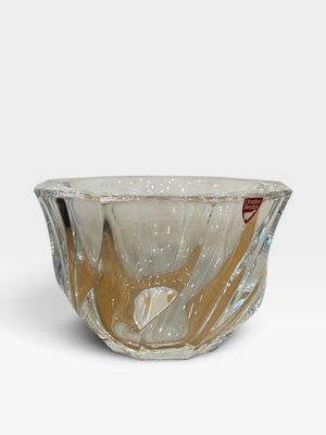 une image représentant un bol en verre posé sur une surface blanche