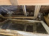 a window in the corner of a room that has a lot of dirt on it