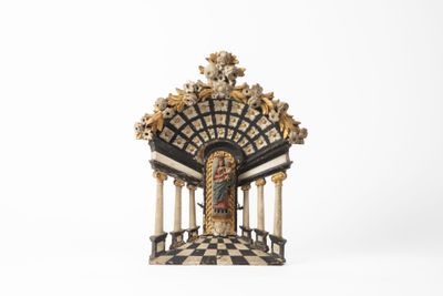 une petite statue représentant un bâtiment avec des colonnes et une horloge au sommet
