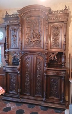 une grande armoire en bois dans une pièce où se trouve une horloge accrochée au mur