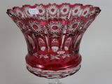 a red glass bowl sitting on top of a glass stand
