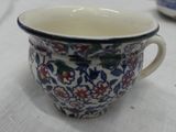 a cup that is sitting on a table with a white table cloth