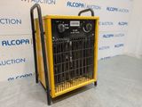 a yellow and black heater sitting on top of a gray floor