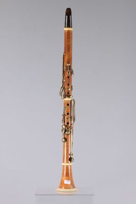 a close up of a wooden clarinet on a clear surface