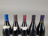 four bottles of wine are lined up in a row