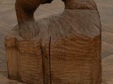 a wooden sculpture of a bear standing on a log