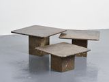 three stone tables sit on top of a cement floor
