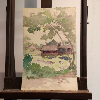 a painting of a house on a easel with a tree in the foreground