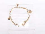 bracelet plaqué or avec des breloques, présenté dans un coffret transparent