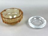 a glass ashtray and a glass ashtray on a table