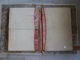 an open book with a red ribbon on top of it
