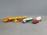several toy trucks are lined up in a row on a gray surface