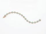 un gros plan d'un bracelet vert et blanc posé sur une surface blanche