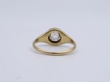 a yellow gold ring with a white diamond in the center