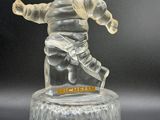 une figurine en verre transparent représentant un homme tenant un bébé dans ses bras