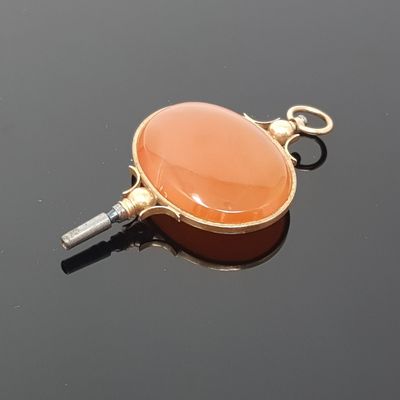 a picture of an orange pendant on a black surface