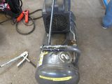 a small air compressor sitting on the ground next to other tools