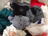 a pile of clothes that is on a bed