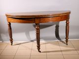 a wooden table with a curved top on a tiled floor