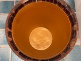 an overhead view of a bowl of liquid on a tiled floor