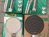 trois types différents de pommeaux de douche, rangés dans des boîtes posées sur un sol carrelé