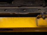 a close up of a yellow metal object on a black background