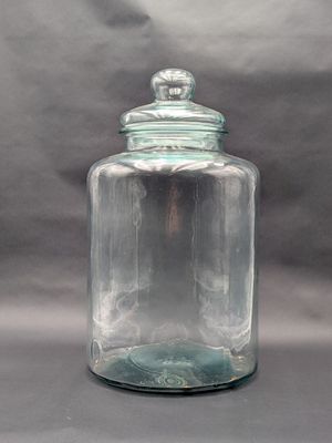 un pot en verre transparent avec un couvercle sur une table