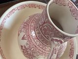 a pink and white cup and saucer sitting on a plate