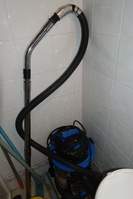 une photo d'une salle de bains avec des toilettes et un tuyau