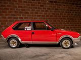 a red car that is parked in front of a brick wall