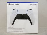 La boîte de la manette PlayStation est posée sur la table.