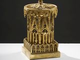 une statue en or représentant une tour surmontée d'une horloge